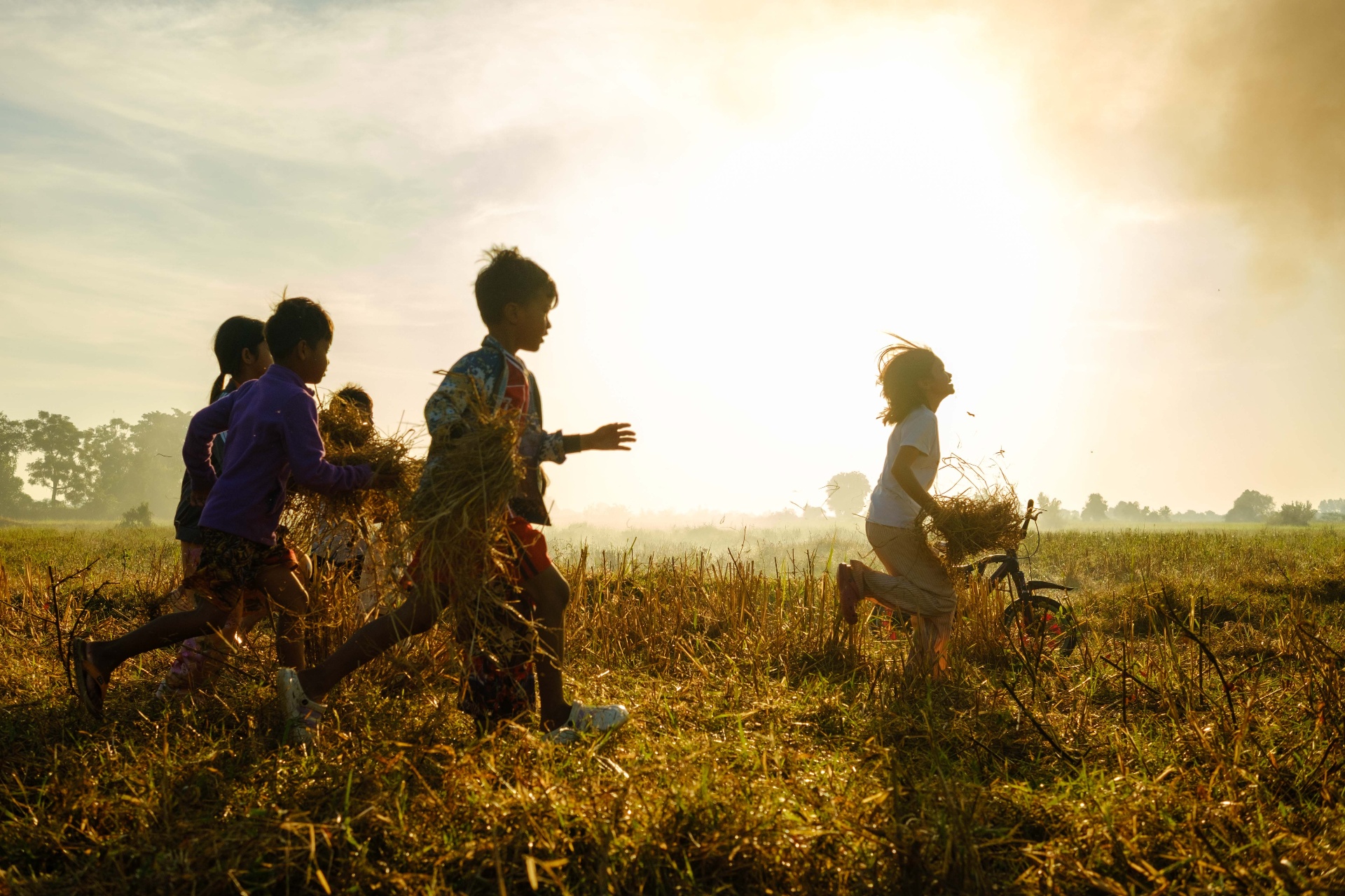 Children running through a sunlit field at golden hour